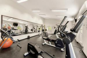 a gym with several treadmills and cardio machines at 101 Sapphire Beach Barbados in Christ Church