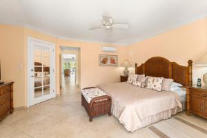 a bedroom with a bed and a ceiling fan at 101 Sapphire Beach Barbados in Christ Church +8 photos