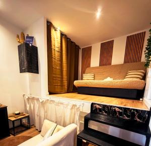 a living room with a bed on a stage at Charmant Studio Climatisé plein centre d'Aubagne in Aubagne