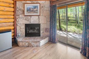 a living room with a fireplace in a log cabin at Daniels Summit Lodge in Wallsburg