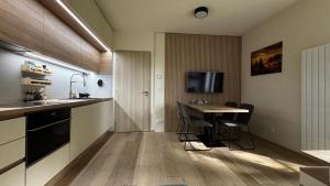a kitchen with a table and a sink and a counter at Apartmán Jasanek in Železná Ruda +8 photos