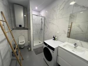 a white bathroom with a sink and a toilet at Loft 130m2 10pers idéal groupe famille in Marseille +4 photos