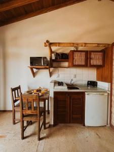 a kitchen with a sink and a table with a chair at Kahuma in Imbituba +8 photos