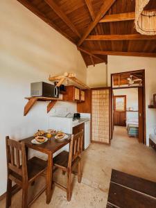 a kitchen with a table and chairs and a kitchen with a stove at Kahuma in Imbituba