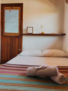 a bedroom with a bed with a towel on it at Kahuma in Imbituba