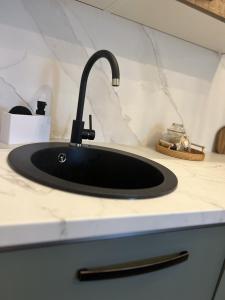 a sink in a counter with a black faucet at One Bedroom Apartment with Terrace in Oradea +27 photos