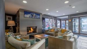 a large living room with couches and a fireplace at Pied des pistes, piscine, jacuzzi in Flaine