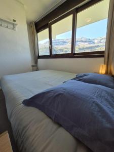 a bedroom with a bed with a view of the mountains at Pied des pistes, piscine, jacuzzi in Flaine +34 photos