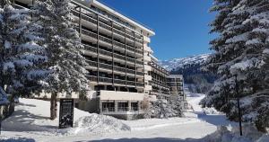 a large building in the snow with snow covered trees at Pied des pistes, piscine, jacuzzi in Flaine