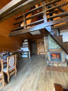a living room with a fireplace in a log cabin at Котедж A-frame Strimba in Verkhnyaya Rozhanka