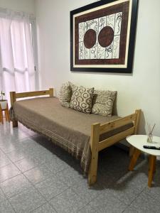 a bed in a room with a couch and a table at Santa Genoveva in Neuquén