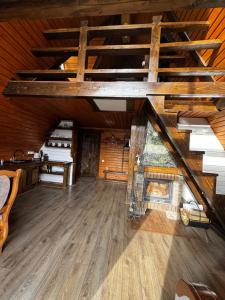 an attic room with a fireplace and wooden floors at Котедж A-frame Strimba in Verkhnyaya Rozhanka