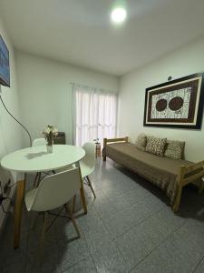 a living room with a bed and a table and chairs at Santa Genoveva in Neuquén +4 photos