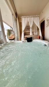 a large bath tub in a bedroom with a bed at Sundowner Hive115 Jacuzzi studio Large grdan patio in Gurgaon