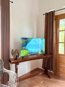a flat screen tv sitting on top of a wooden table at De Cabin Situjuah in Situjuhbatul