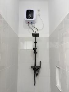 a white tiled bathroom with a camera on the wall at De Cabin Situjuah in Situjuhbatul +82 photos