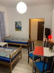 a room with two beds and a table and chairs at Noclegi AVATAR Radom in Radom +8 photos