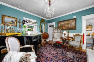 a living room with a grand piano and chairs at The Gaslamp Bed and Breakfast in Provincetown