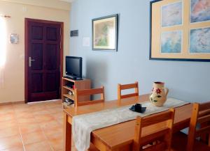 Una sala de estar con una mesa y un televisor. en El Varadero, en Igueste
