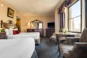 a hotel room with two beds and a table at The Whitehall Hotel - BW Premier Collection in Chicago