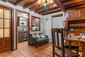 a kitchen and living room with a table and a couch at La Casina Del Fornu in Pravia