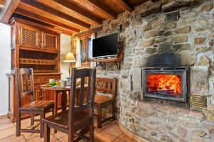 a living room with a fireplace and a table and chairs at La Casina Del Fornu in Pravia