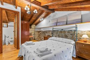 a bedroom with a bed with towels on it at La Casina Del Fornu in Pravia