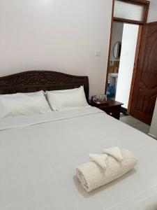 a bedroom with a white bed with two towels on it at Beytumn Luxury Apartment - Ruiru in Nairobi