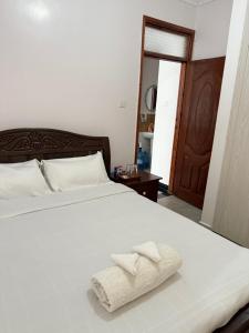 a bedroom with a white bed with two towels on it at Beytumn Luxury Apartment - Ruiru in Nairobi