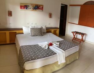 a bedroom with a large bed with white sheets at POUSADA LUATOUR Praia Pontal do Coruripe in Coruripe +44 photos