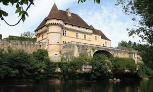 a castle on a bridge over a river at La Maison du Gardien in La Celle-sous-Gouzon