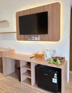 a room with a table with a tv on a wall at De Cabin Situjuah in Situjuhbatul