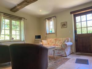 a living room with a couch and a table at La Maison du Gardien in La Celle-sous-Gouzon