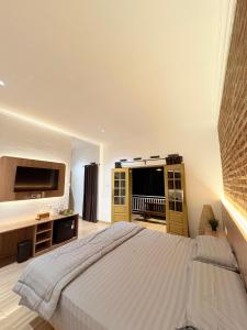 a bedroom with a large bed and a television at De Cabin Situjuah in Situjuhbatul