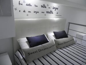 シラクーサにあるIl Vittorialeのベッドルーム1室(壁に文字が付いたベッド1台付)