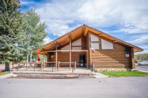 a log cabin with a large porch in a parking lot at Daniels Summit Lodge in Wallsburg