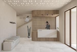 a man standing at a counter in a lobby at Enavlion Elegance Seaside Luxury in Chrysi Ammoudia