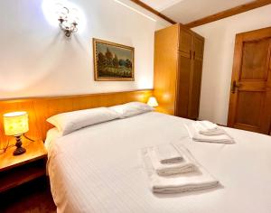 a bedroom with a bed with two towels on it at Cortina Relax in Cortina dʼAmpezzo