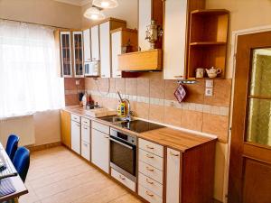 a kitchen with a sink and a stove top oven at Èlmèny Vendègház in Csurgó