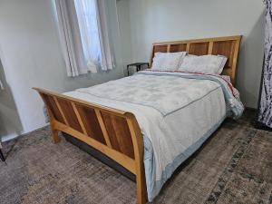 a bedroom with a large bed with a wooden frame at Modern 1 Bedroom Apartment Near Roseau in Canefield