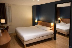 a hotel room with two beds and a mirror at Kyriad Montargis Amilly in Amilly