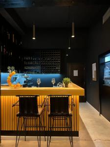 a bar with two chairs at a yellow counter at Apartments & rooms Concept Nordica in Žabljak