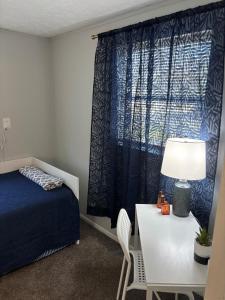 a bedroom with a bed and a table with a lamp at Urban Oasis in Jacksonville