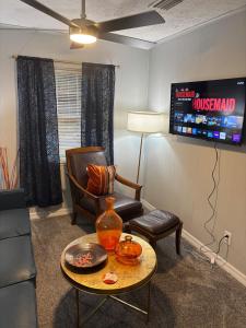 a living room with a chair a table and a tv at Urban Oasis in Jacksonville