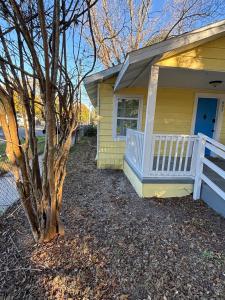 a yellow house with a tree in front of it at Urban Oasis in Jacksonville