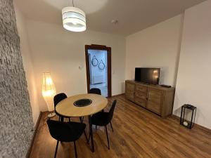 a room with a table and chairs and a television at An der Neiße in Görlitz +48 photos