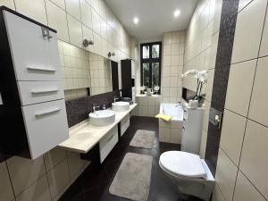 a bathroom with two sinks and a toilet in it at An der Neiße in Görlitz