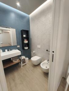 a bathroom with a white toilet and a sink and a toilet istg at L'Oasi del Poeta in Crotone +24 photos