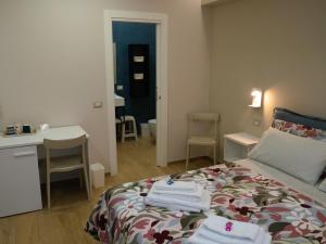 a bedroom with a bed with towels on it at L'Oasi del Poeta in Crotone