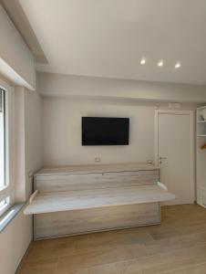 a living room with wooden shelves and a flat screen tv at L'Oasi del Poeta in Crotone